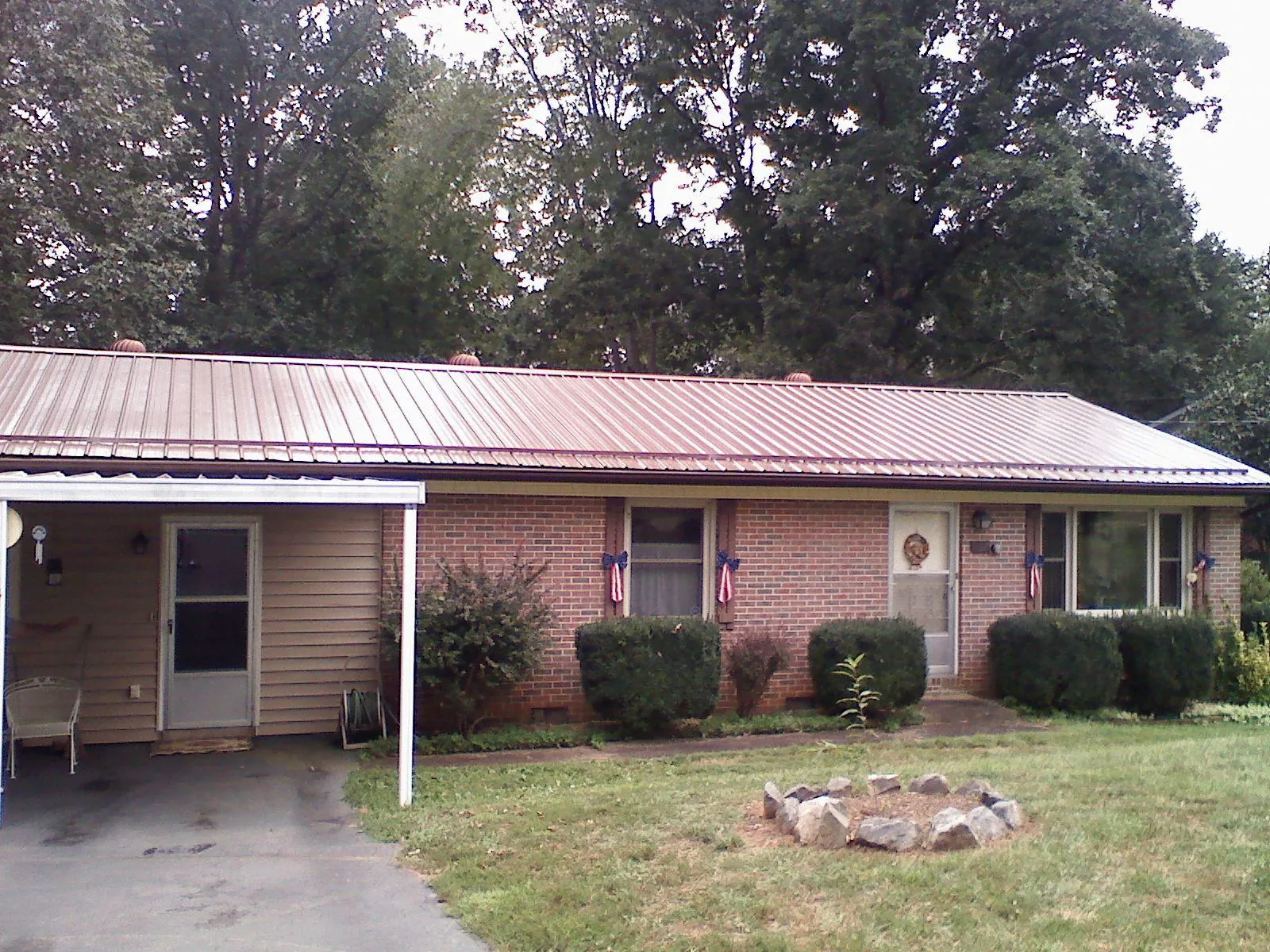 Bronze metal roof and carport on a brick ranch home — Roof Repair work by our crew in Halifax